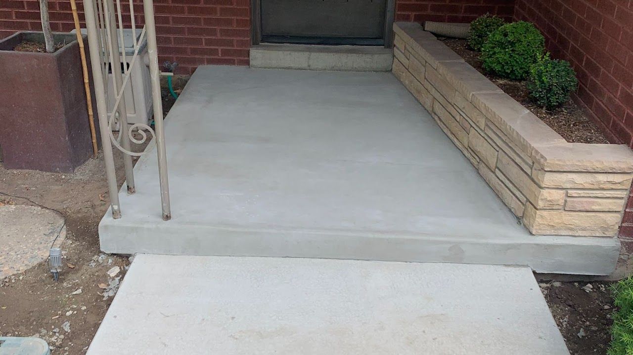 A brick building with a concrete walkway leading to it.