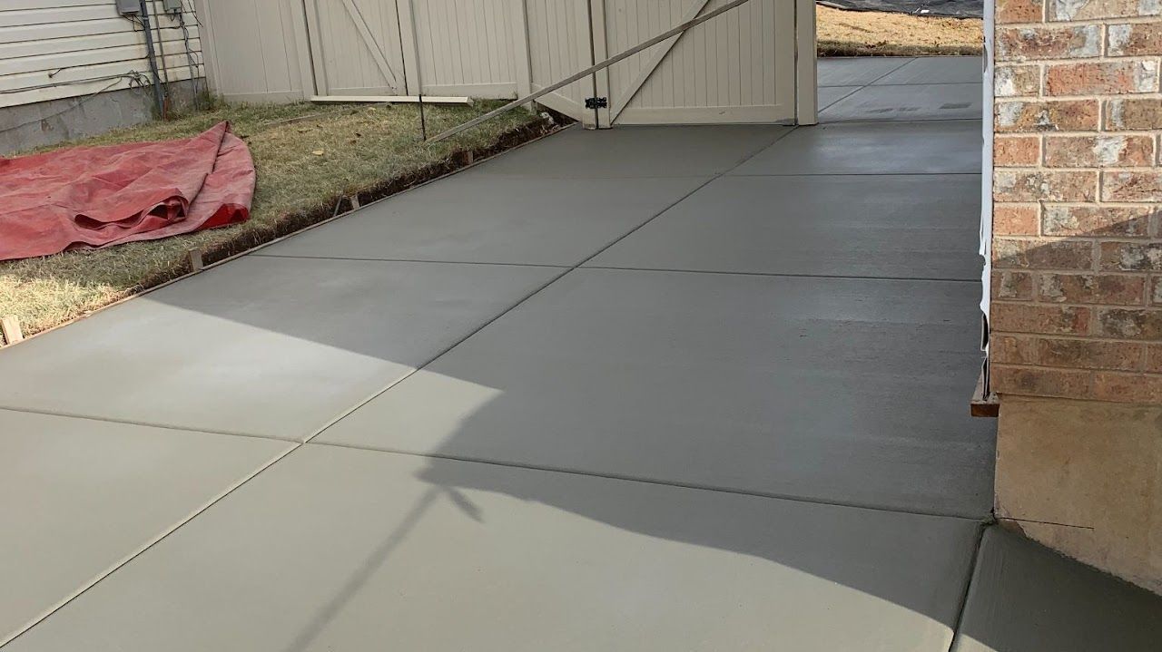 A concrete driveway is being built next to a brick building.