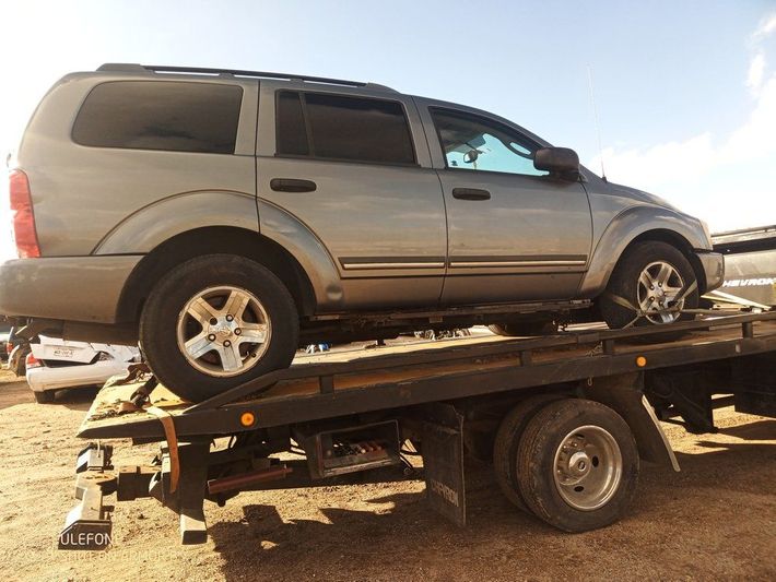 A silver suv is sitting on top of a tow truck A silver suv is sitting on top of a tow truck