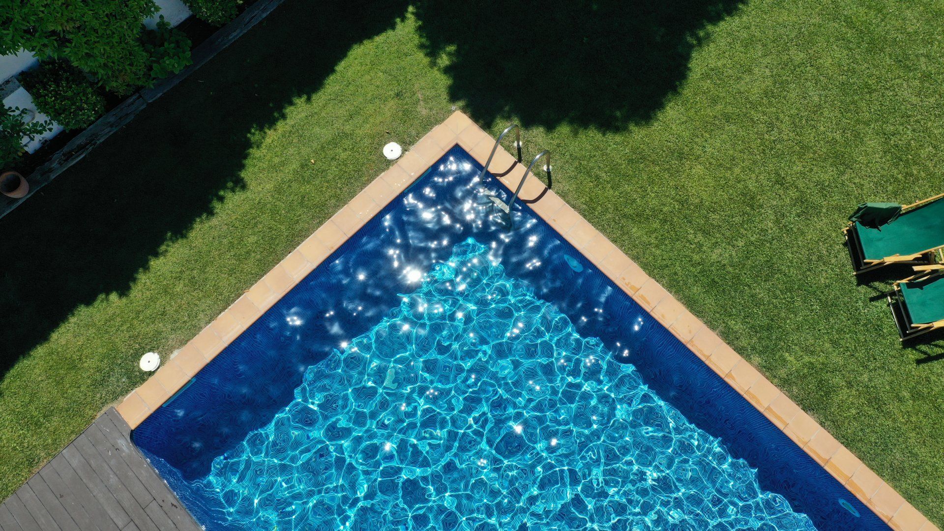 An aerial view of a large swimming pool surrounded by lawn chairs.
