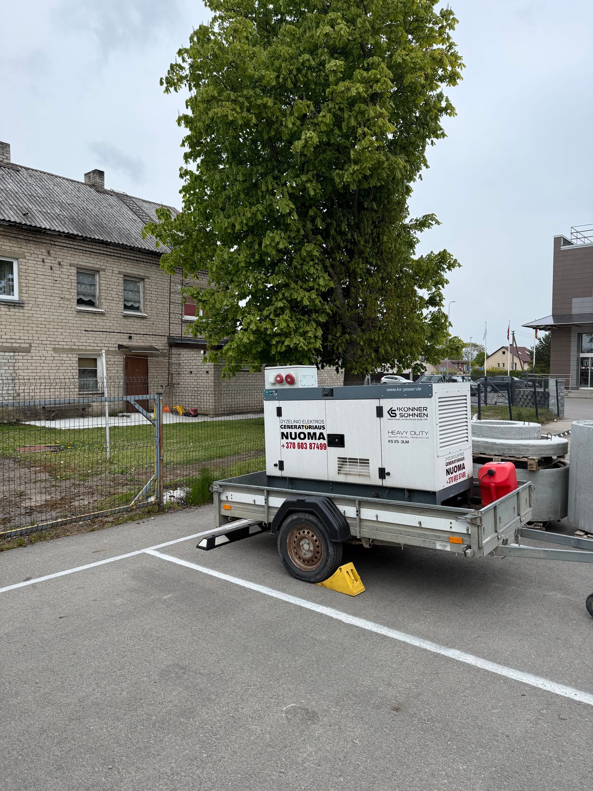 Priekaba su ant jos pastatytu generatoriumi pastatyta automobilių stovėjimo aikštelėje.
