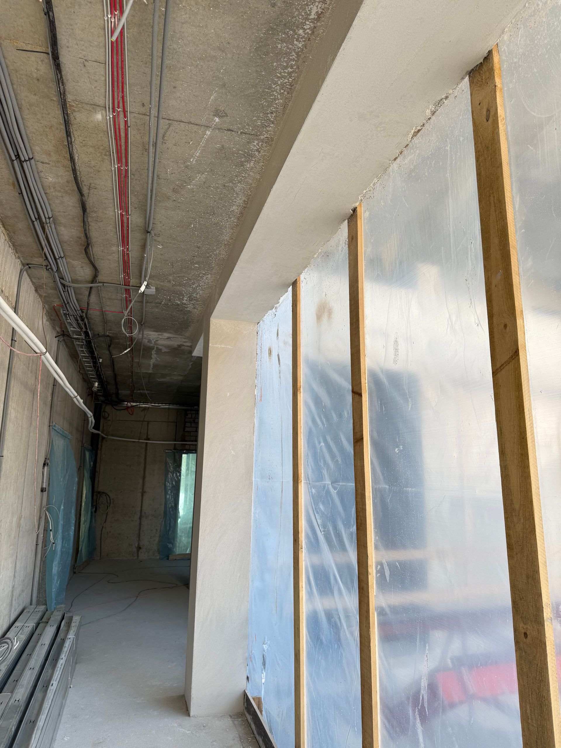 Statomo pastato koridorius, kurio langai dengti plastiku.