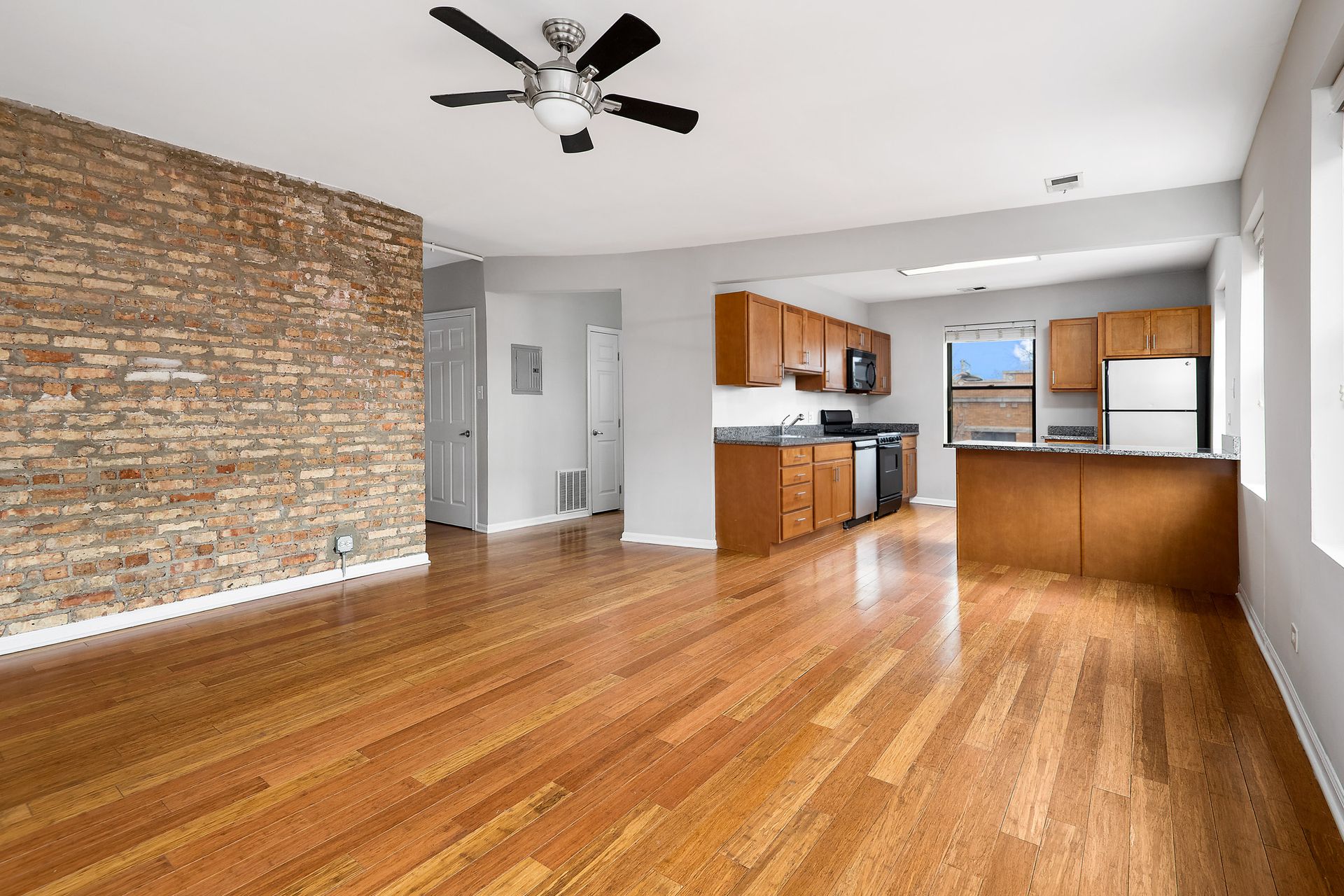 Living room and kitchen with hardwood floors at 1640 N Damen Apartments.
