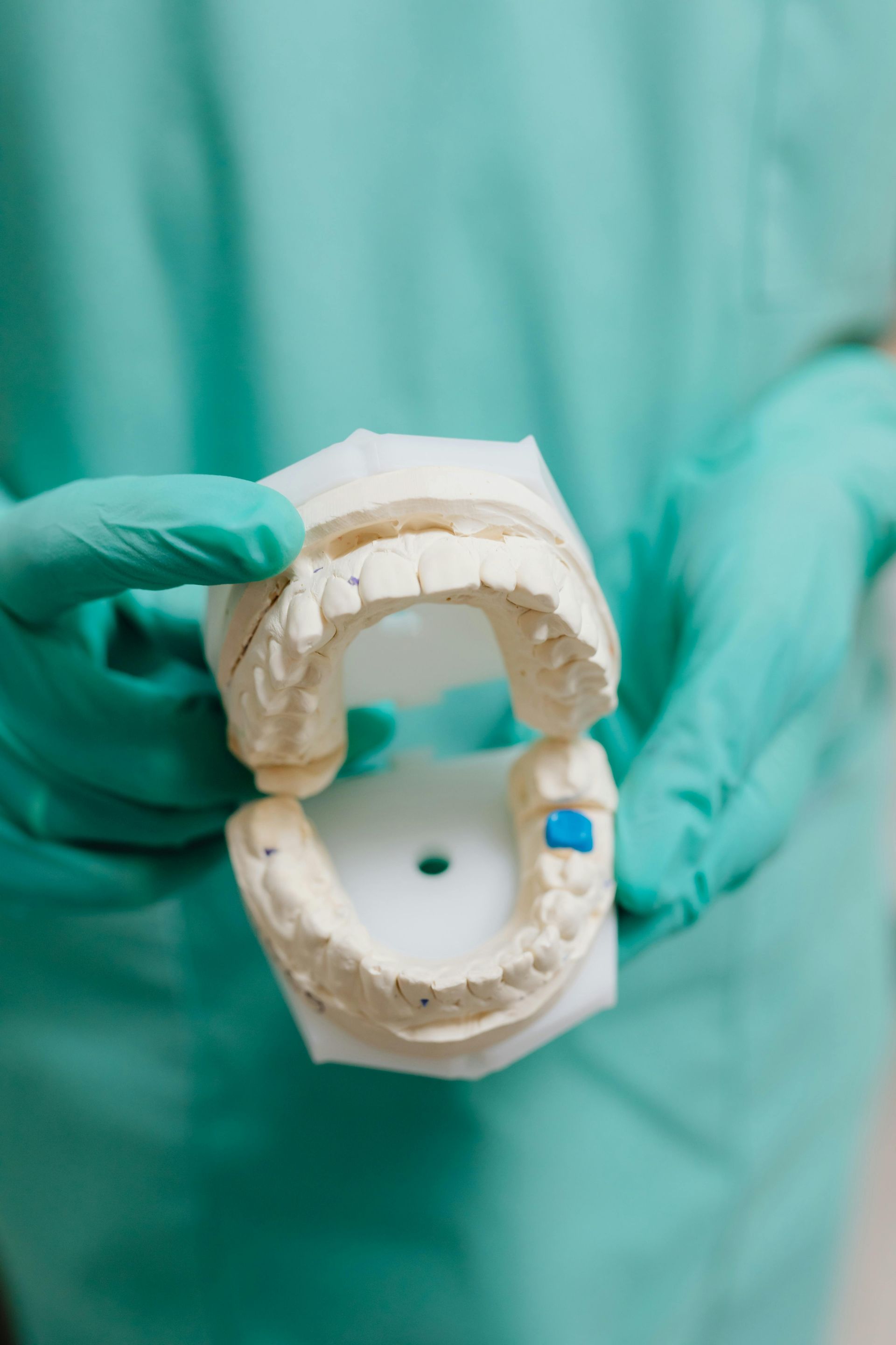 Dentist holding a dental mold with a clear retainer.