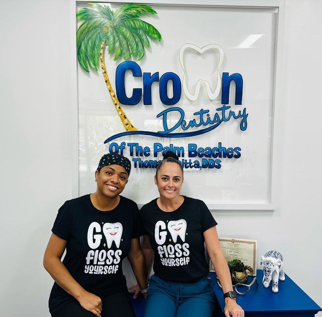 Two women in black t-shirts with tooth design in front of 