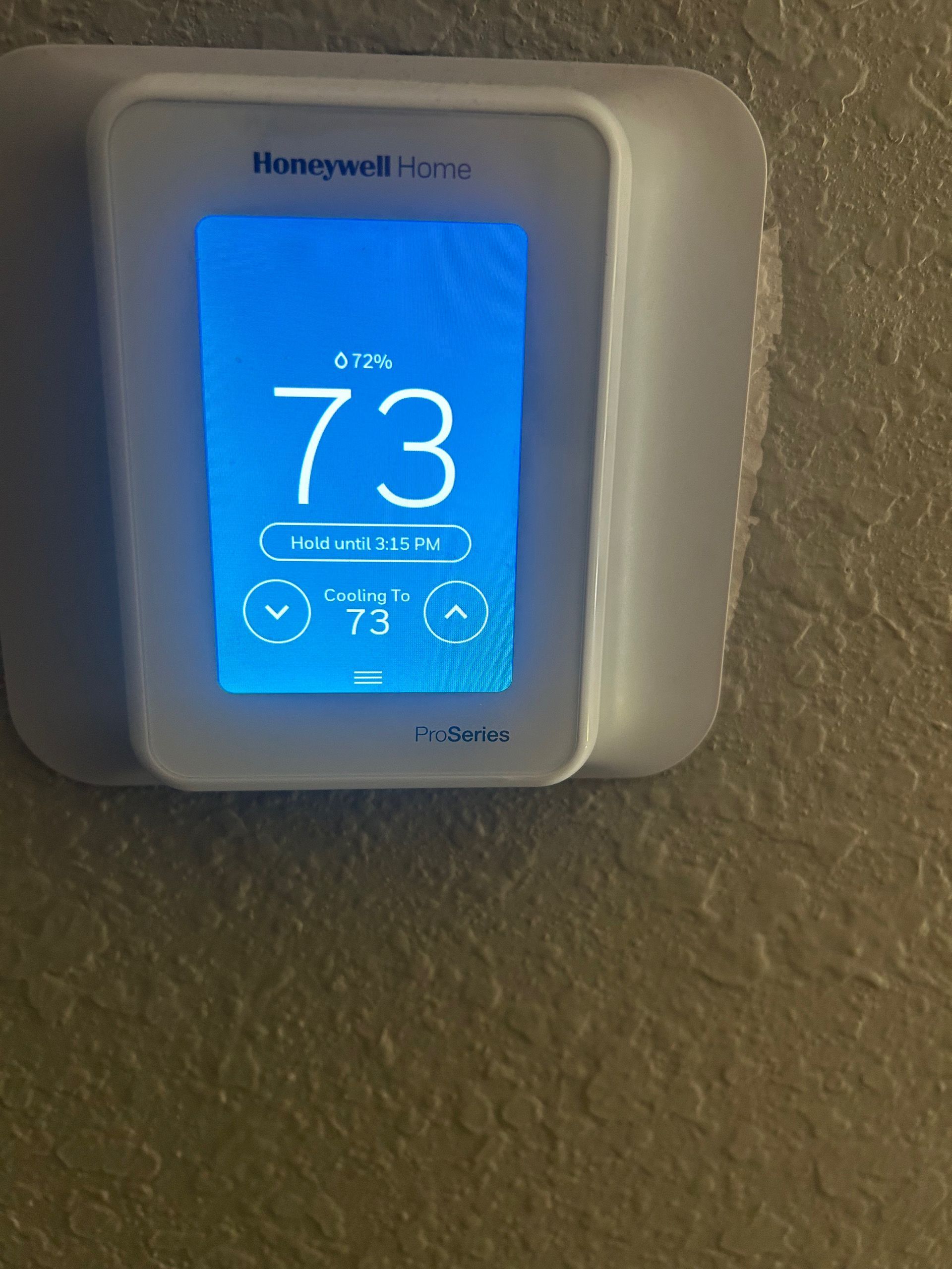 Honeywell smart thermostat showing room temperature of 73 degrees. Current setting also 73.