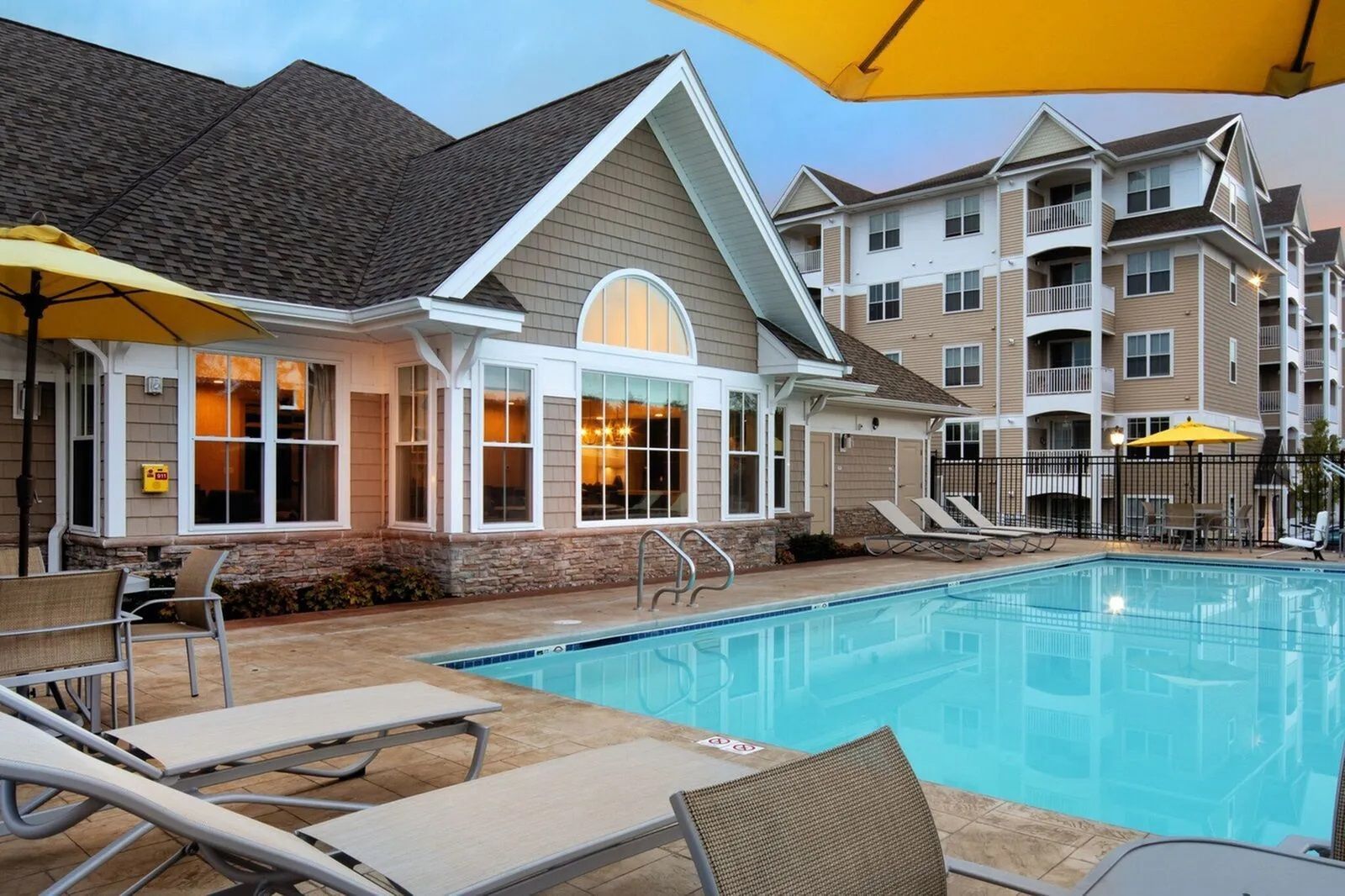 The Residences At Great Pond apartment pool with poolside chairs.