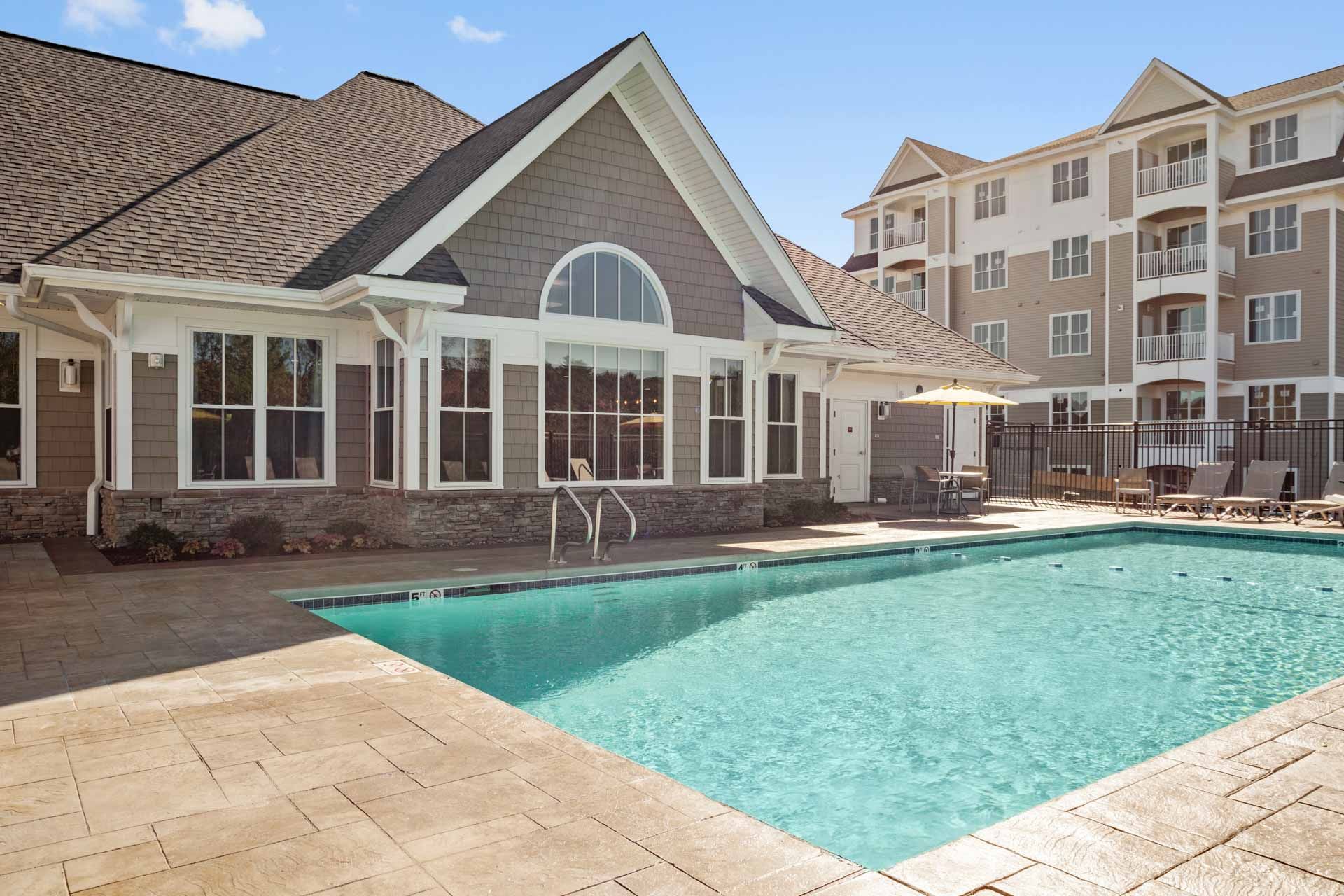 The Residences At Great Pond clubhouse exterior view and outdoor pool.