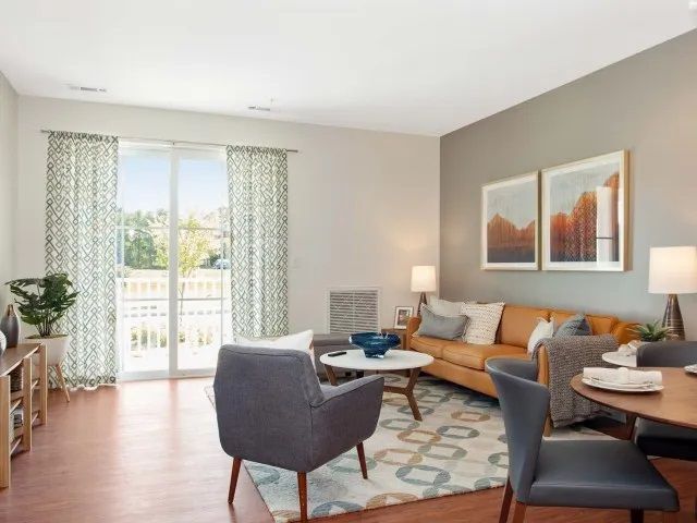 The Residences at Great Pond spacious apartment living room with furniture and an exit to the balcony.