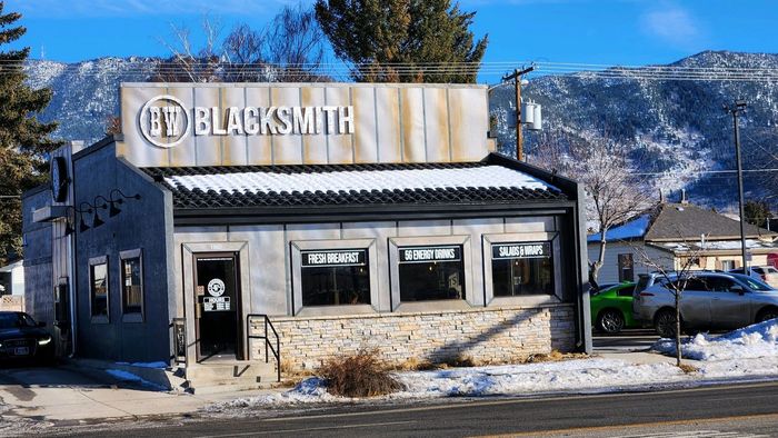 a building with a sign that says blacksmith is sitting on the side of the road