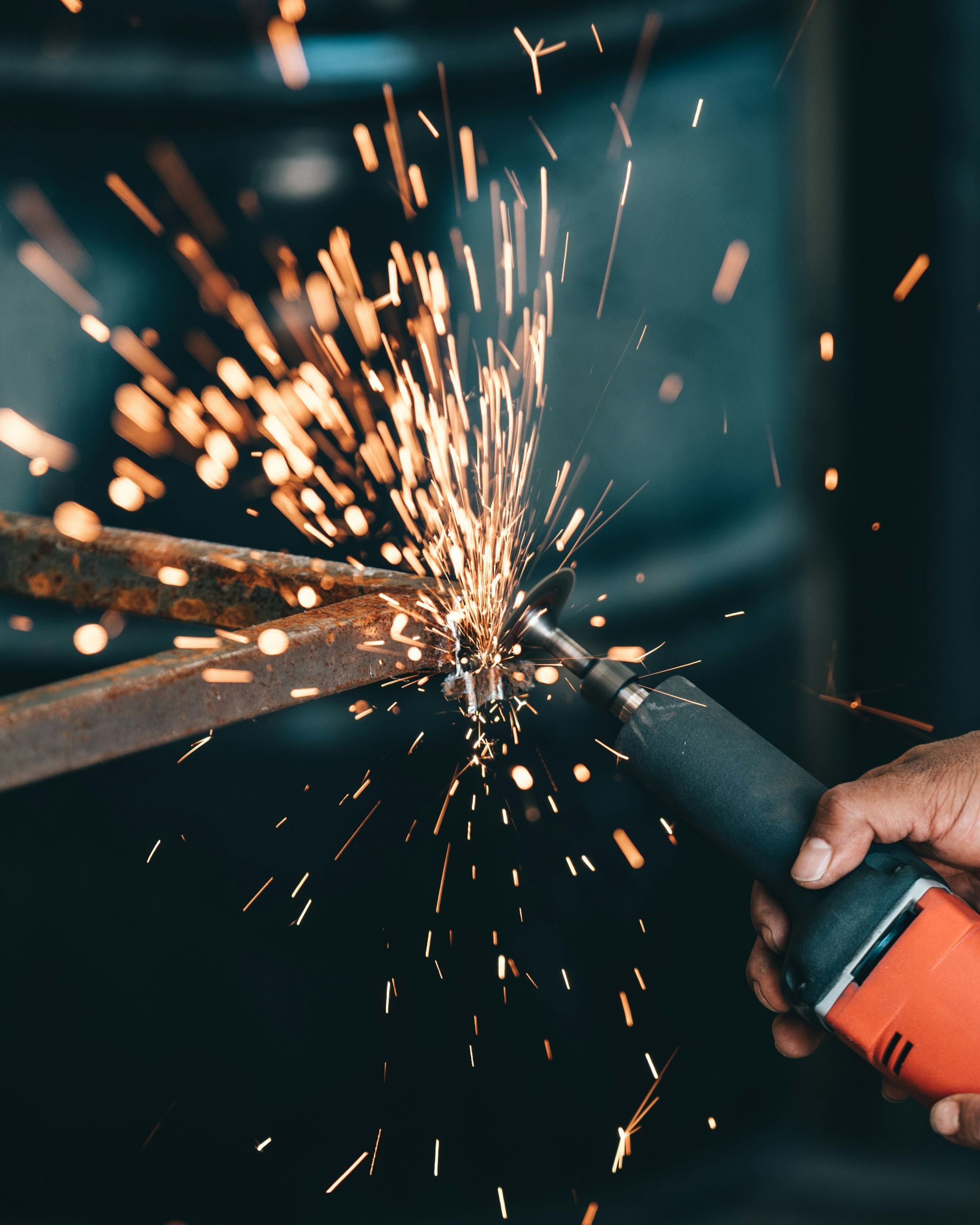 a person is grinding a piece of metal with sparks coming out of it .