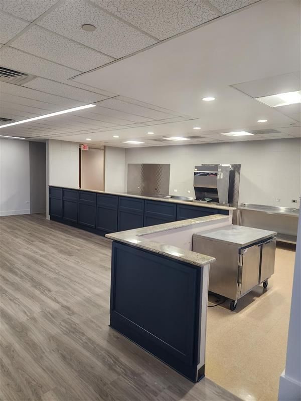 A kitchen with stainless steel appliances and wooden floors - Elgin, IL - Omni Commercial Group, Inc