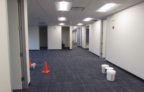 An empty hallway with buckets and cones on the floor