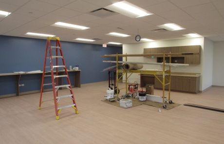 An empty room with a ladder and scaffolding in it