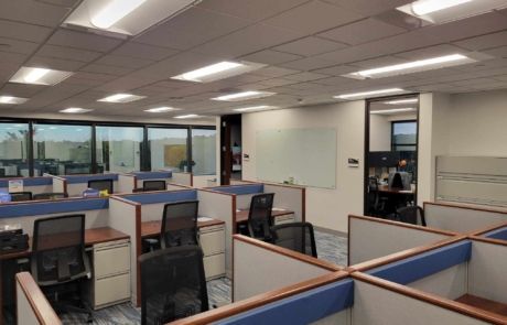A large office with cubicles and chairs in it