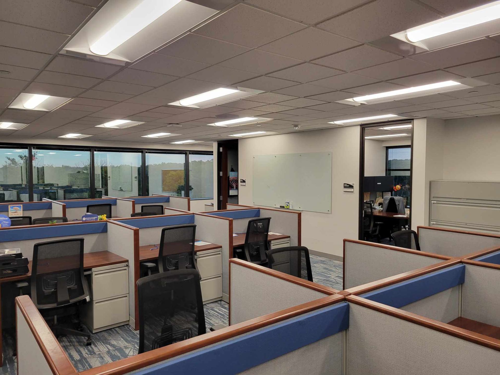 A large office with cubicles and chairs in it
