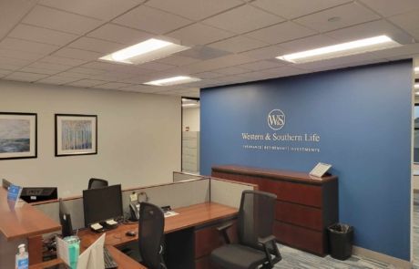 A cubicle in an office with a blue wall and a sign on the wall.