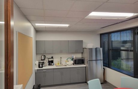 A kitchen with a refrigerator , microwave , and coffee maker.