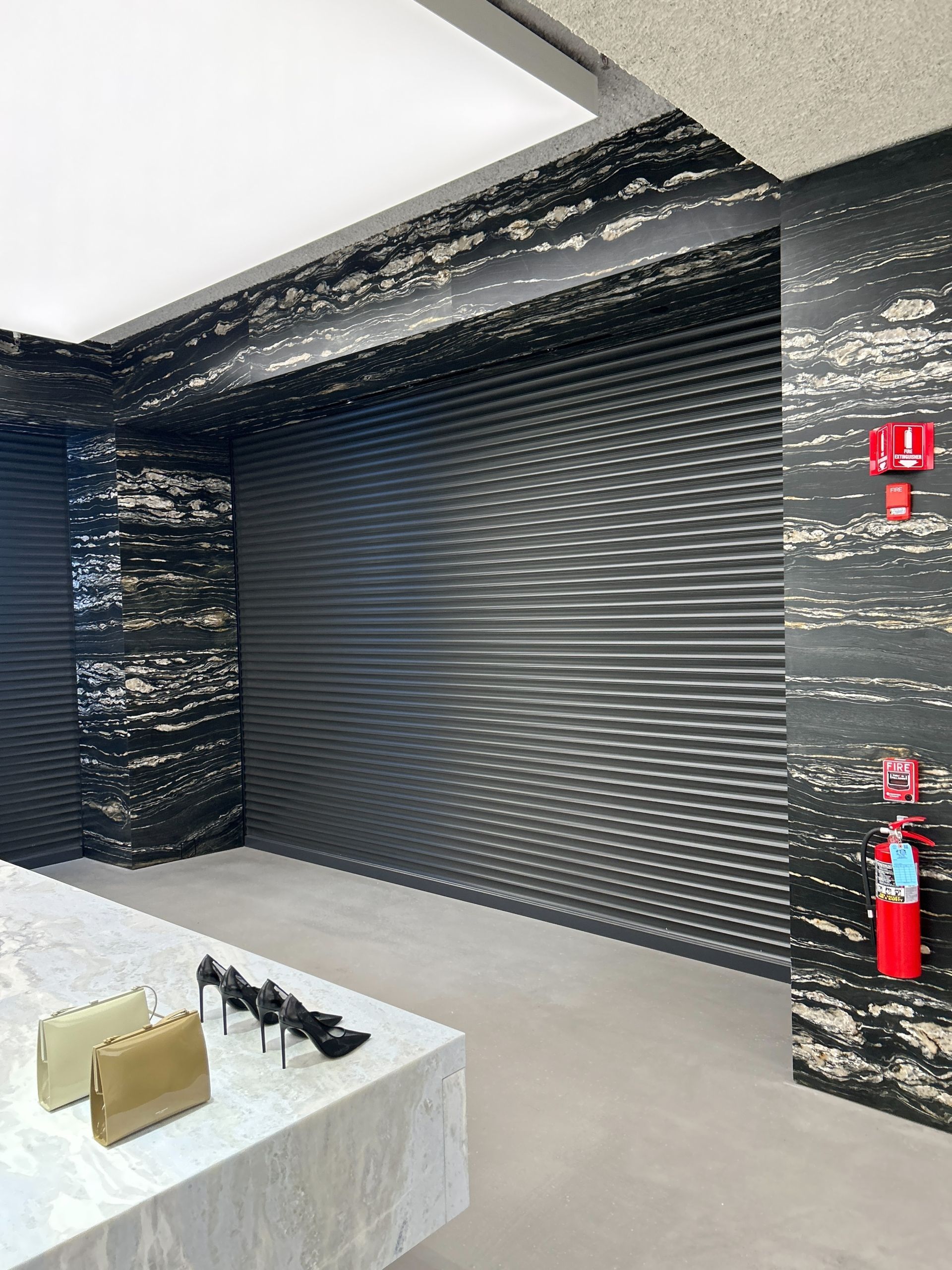 A room with a fire extinguisher and a table with shoes on it