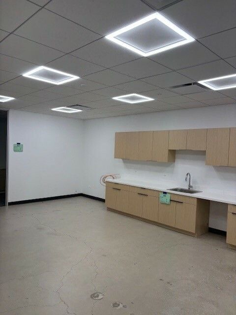 An empty kitchen with wooden cabinets and a sink