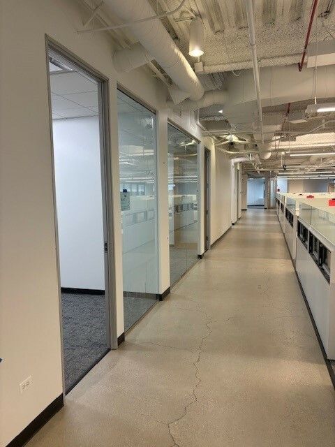 A long hallway in an office building with glass doors