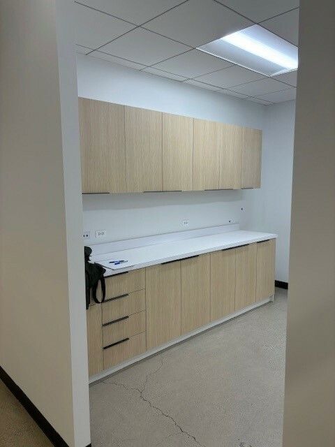 A kitchen with wooden cabinets and white counter tops