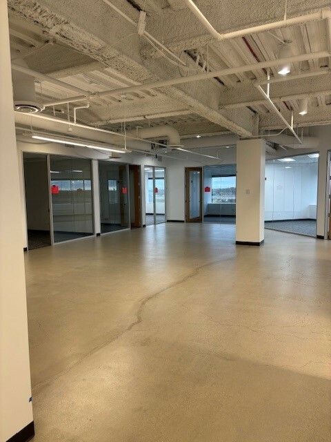 A large empty room with a tan floor and white walls
