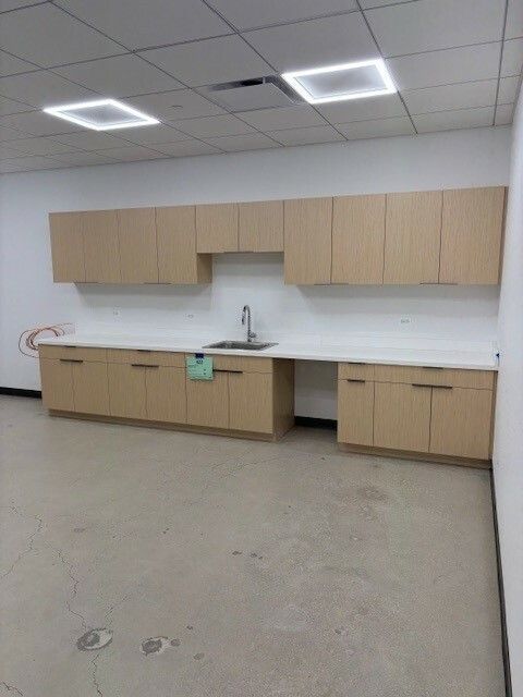 An empty kitchen with wooden cabinets and a sink