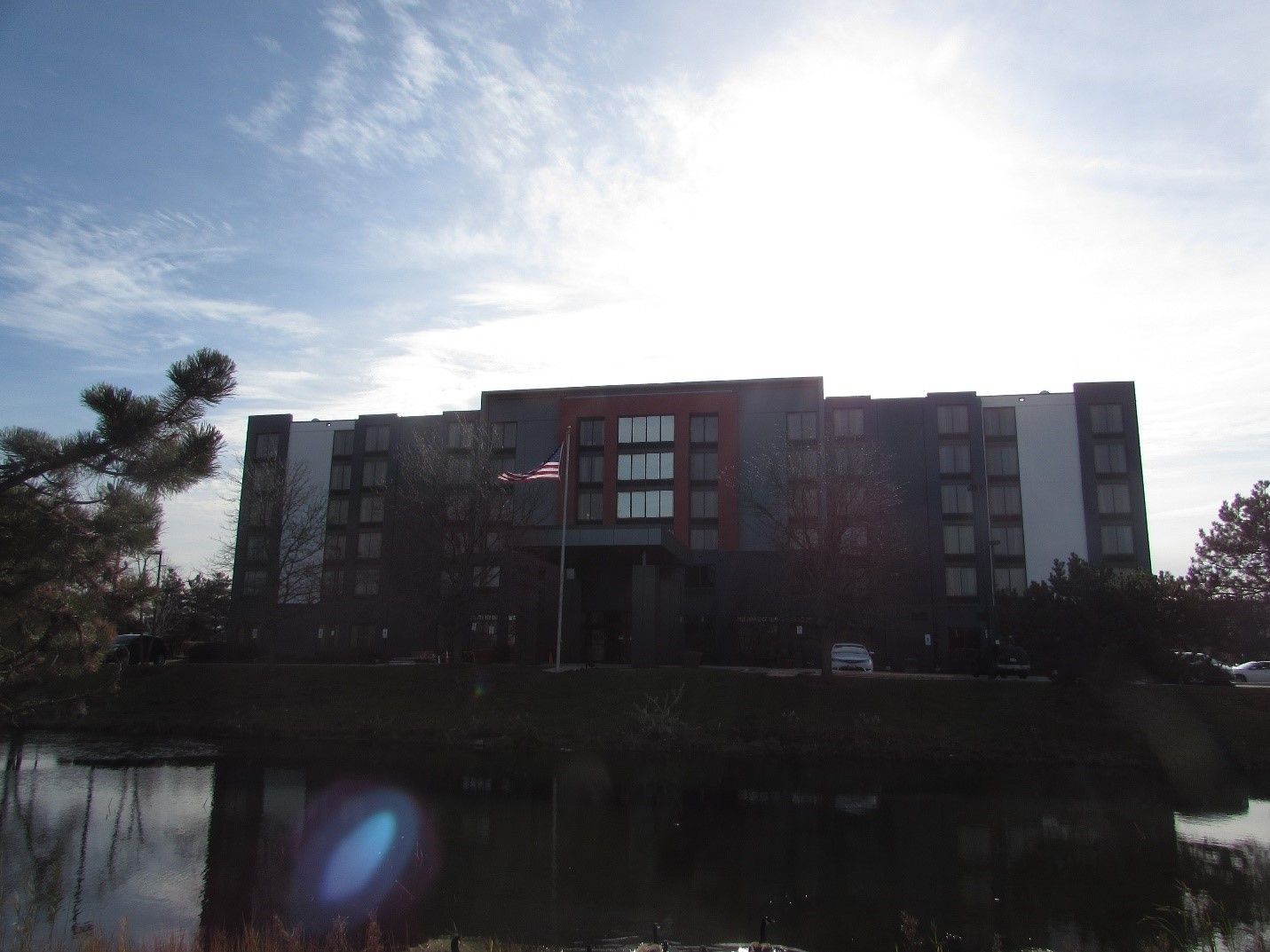 A large building with a pond in front of it