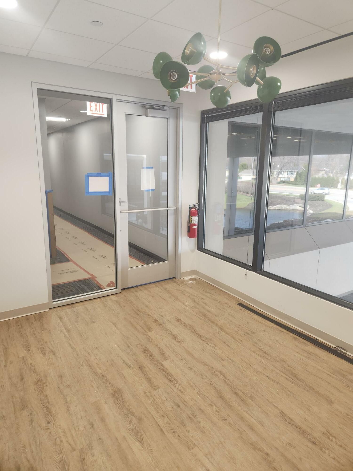 An empty room with a glass door and balloons hanging from the ceiling.