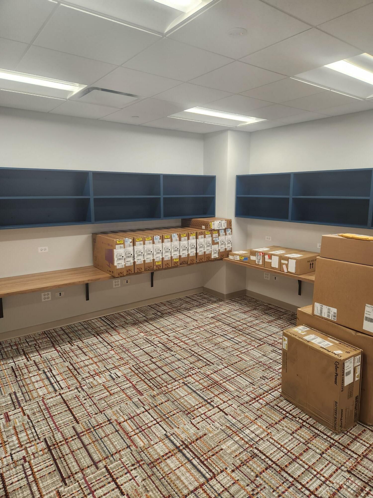 A room with a lot of boxes on the floor and shelves.