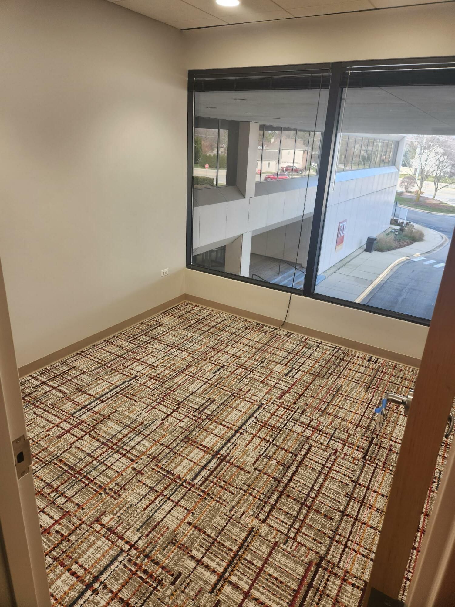 A room with a carpeted floor and a large window.