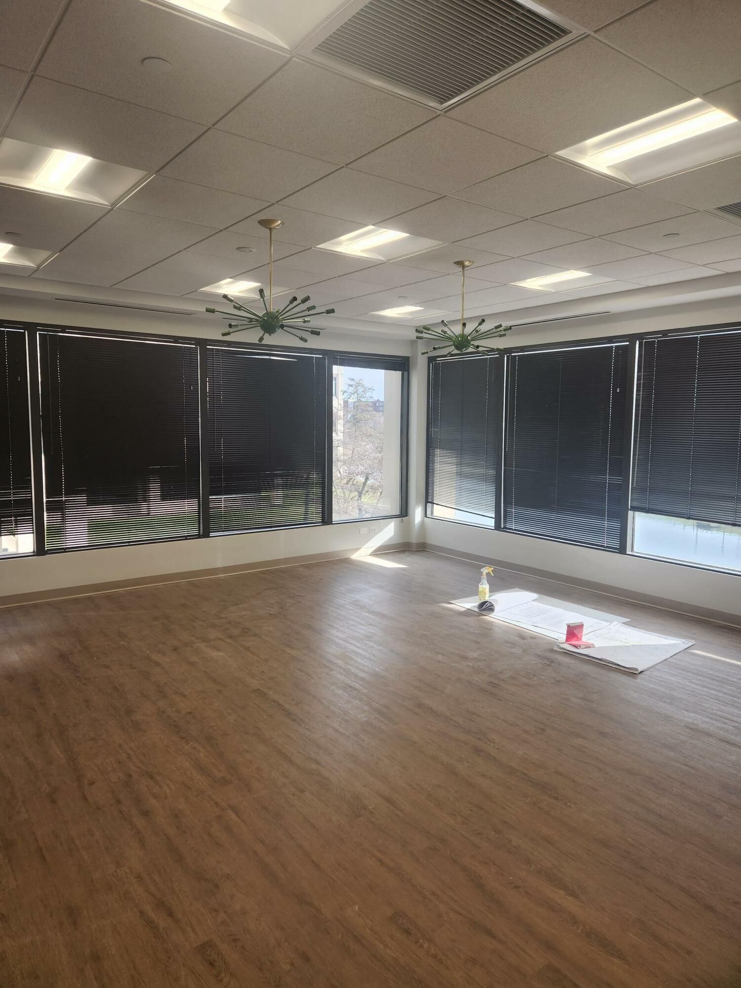 A large empty room with wooden floors and lots of windows.