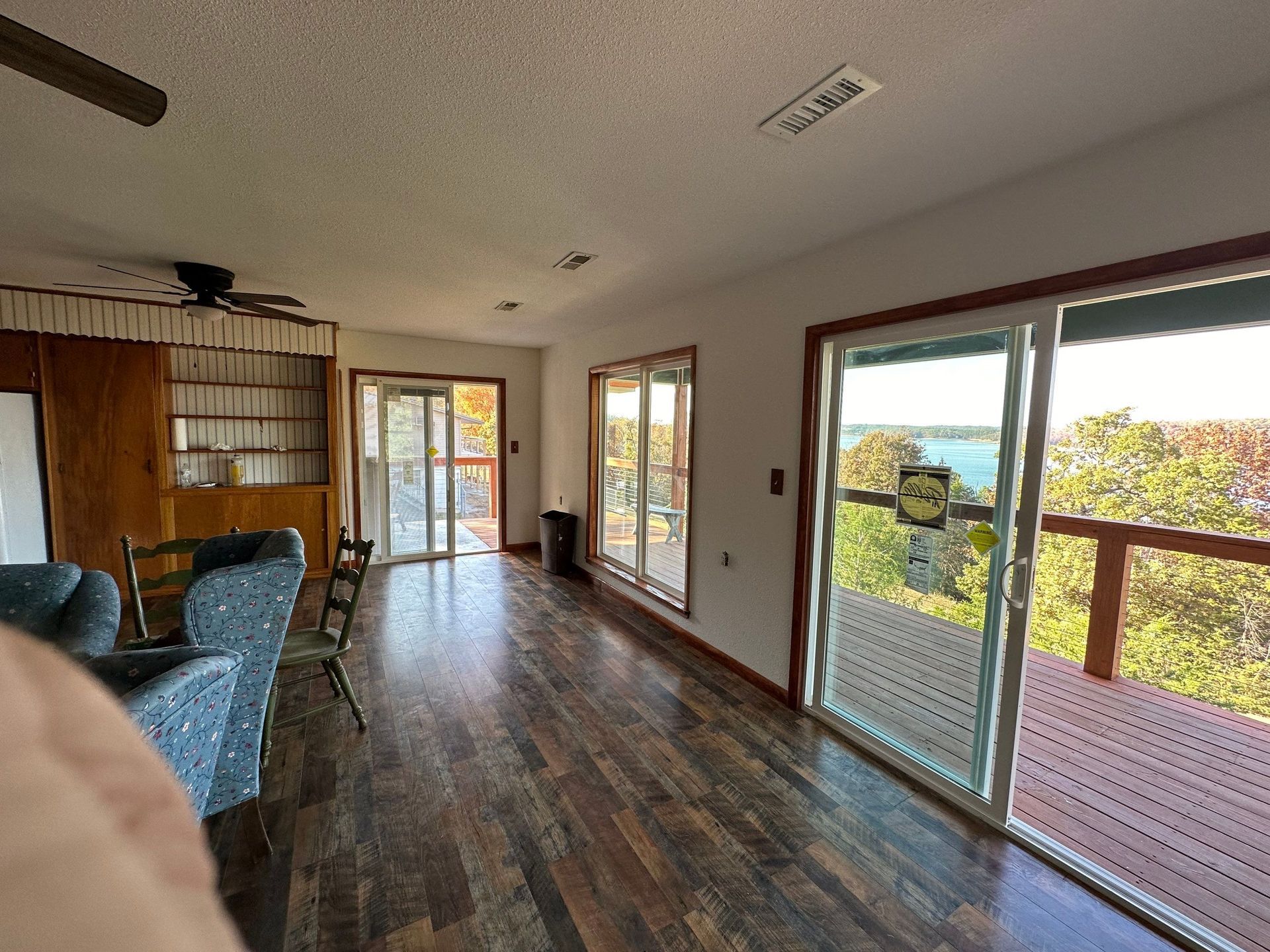 Spacious living room with hardwood floors, sliding glass doors, and a view of trees.