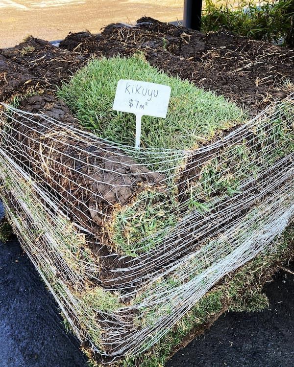 A Stack Of Rolls Of Grass With A Sign On It — Schutz Landscape and Garden Supplies in Tomerong, NSW