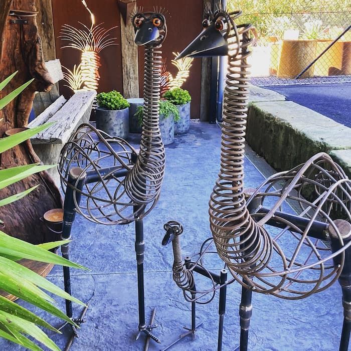 Three Metal Sculptures Of Birds Are Standing Next To Each Other On A Patio — Schutz Landscape and Garden Supplies in Nowra, NSW