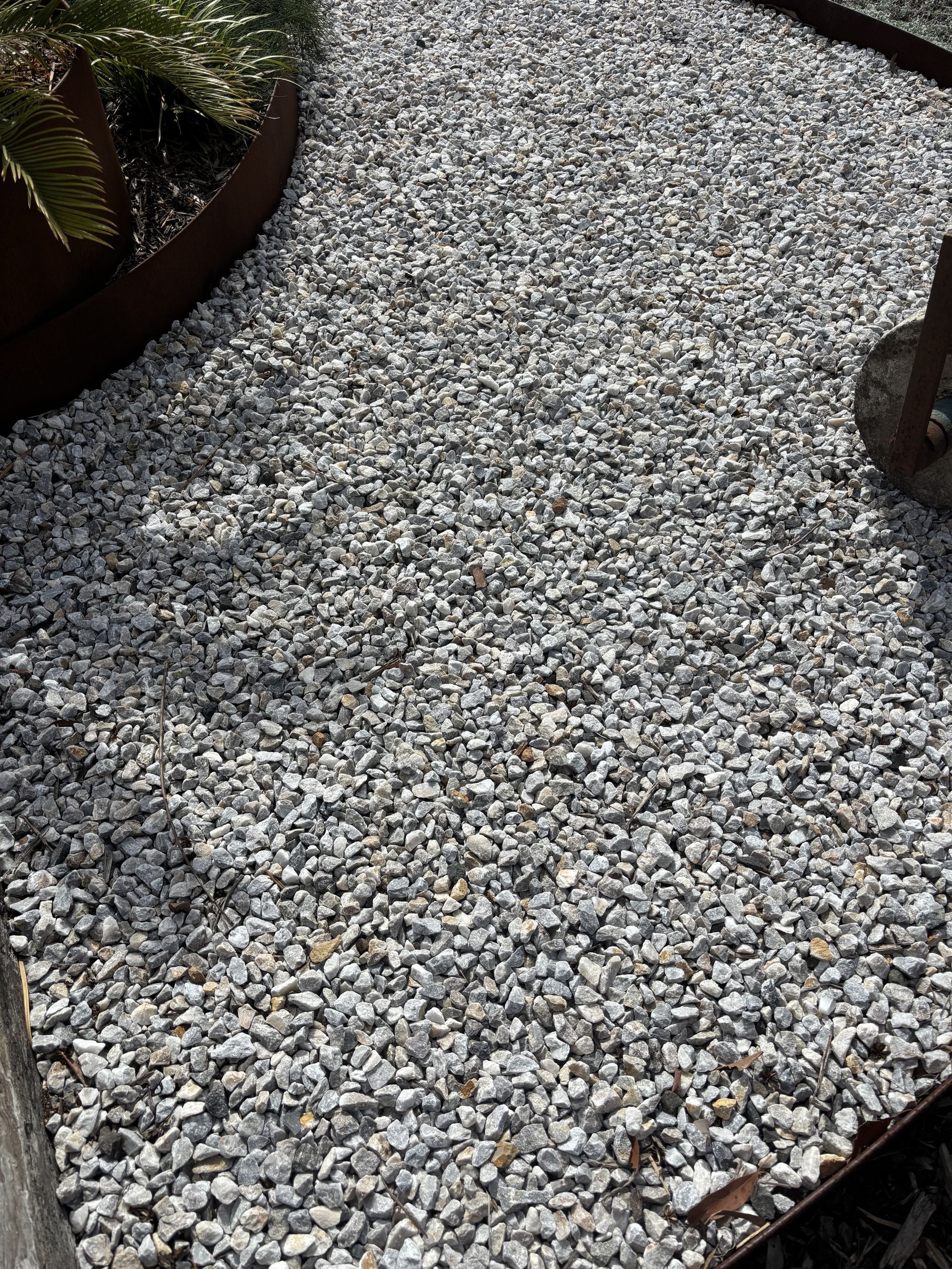 Gravel pathway in a garden bed with a rusted metal border  — Schutz Landscape and Garden Supplies in Tomerong, NSW