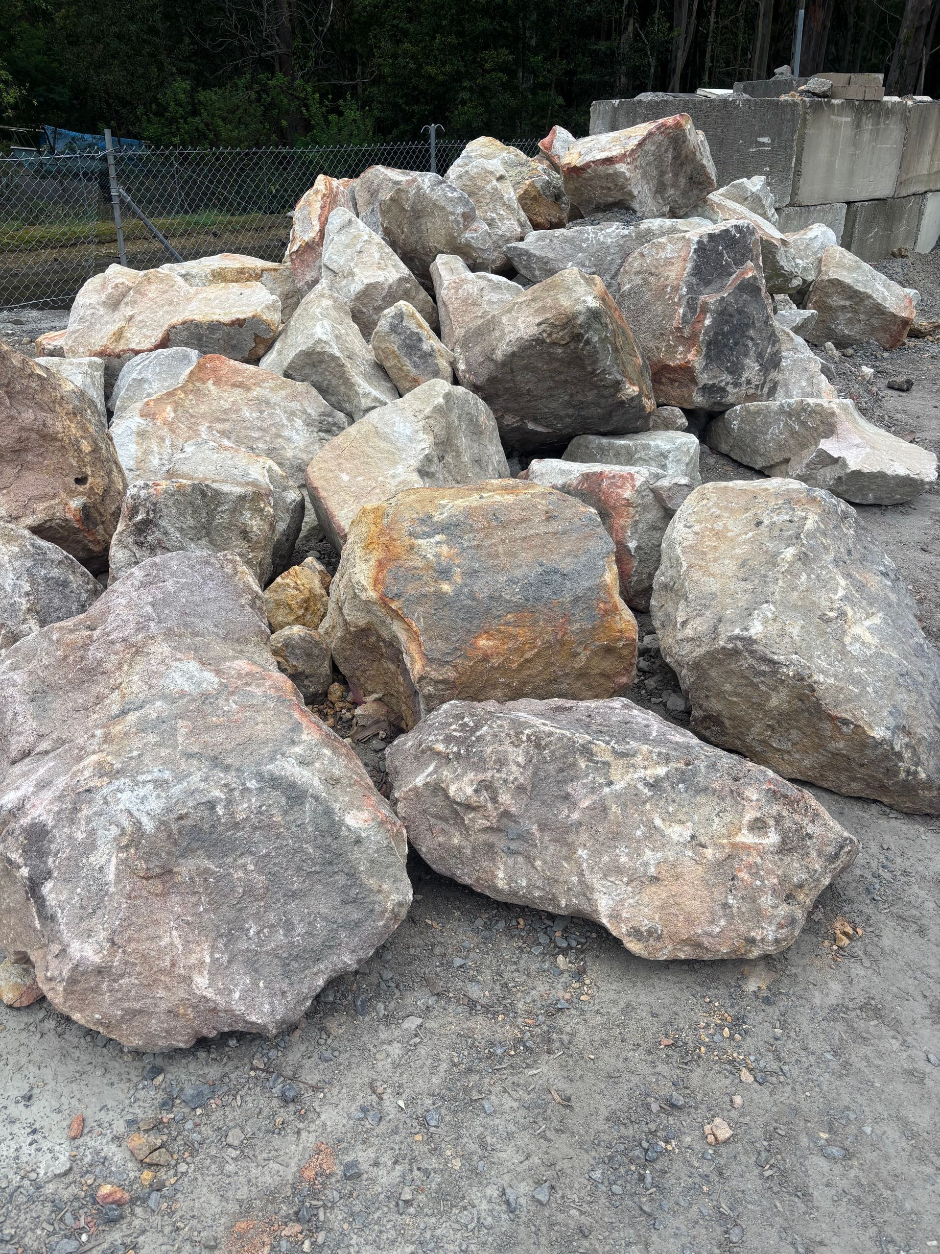 Pile of large, rough-hewn granite boulders in shades of gray, brown, and beige — Schutz Landscape and Garden Supplies in Tomerong, NSW