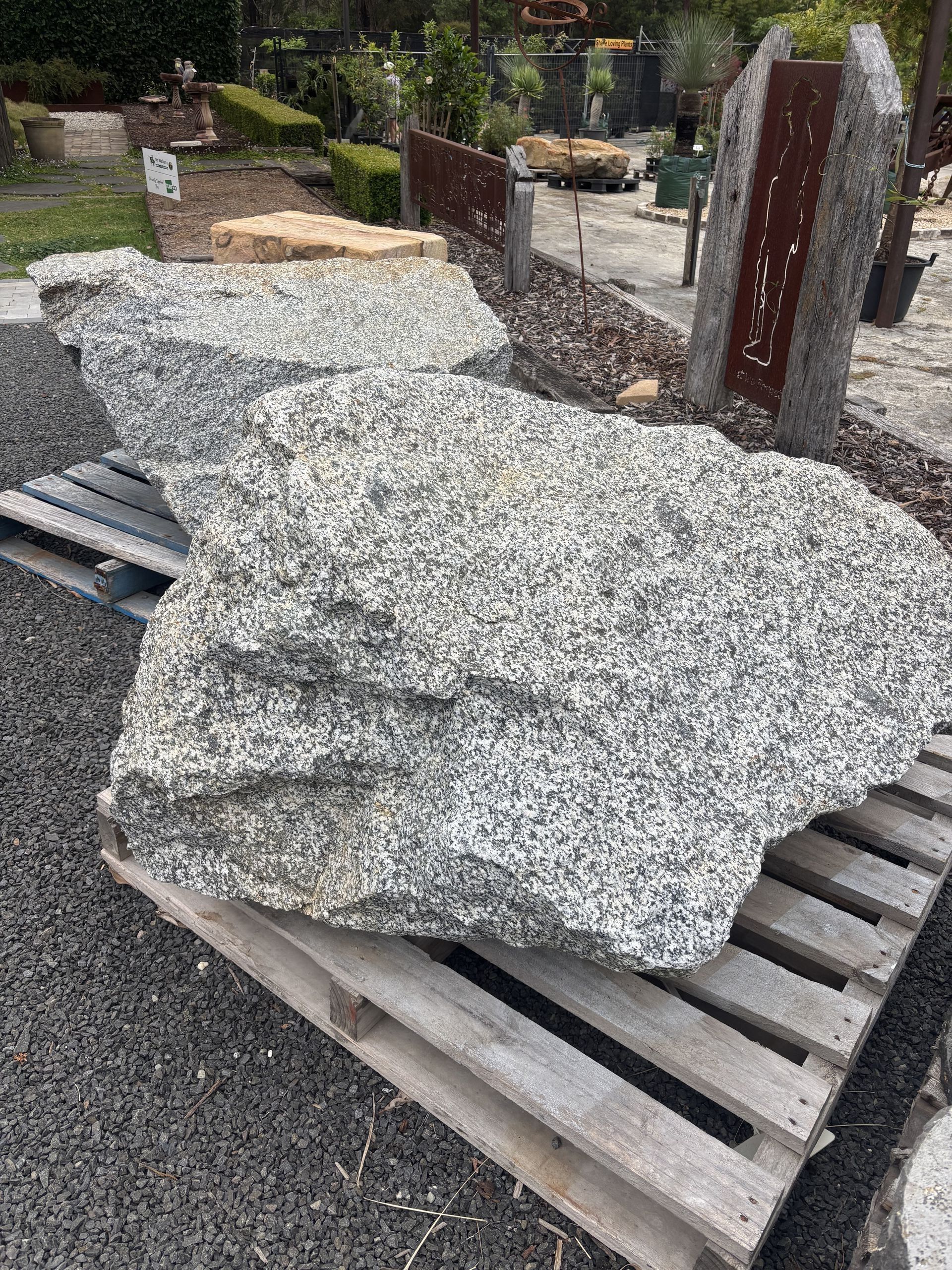 Large granite boulder on wooden pallets at an outdoor landscape supply store — Schutz Landscape and Garden Supplies in Tomerong, NSW