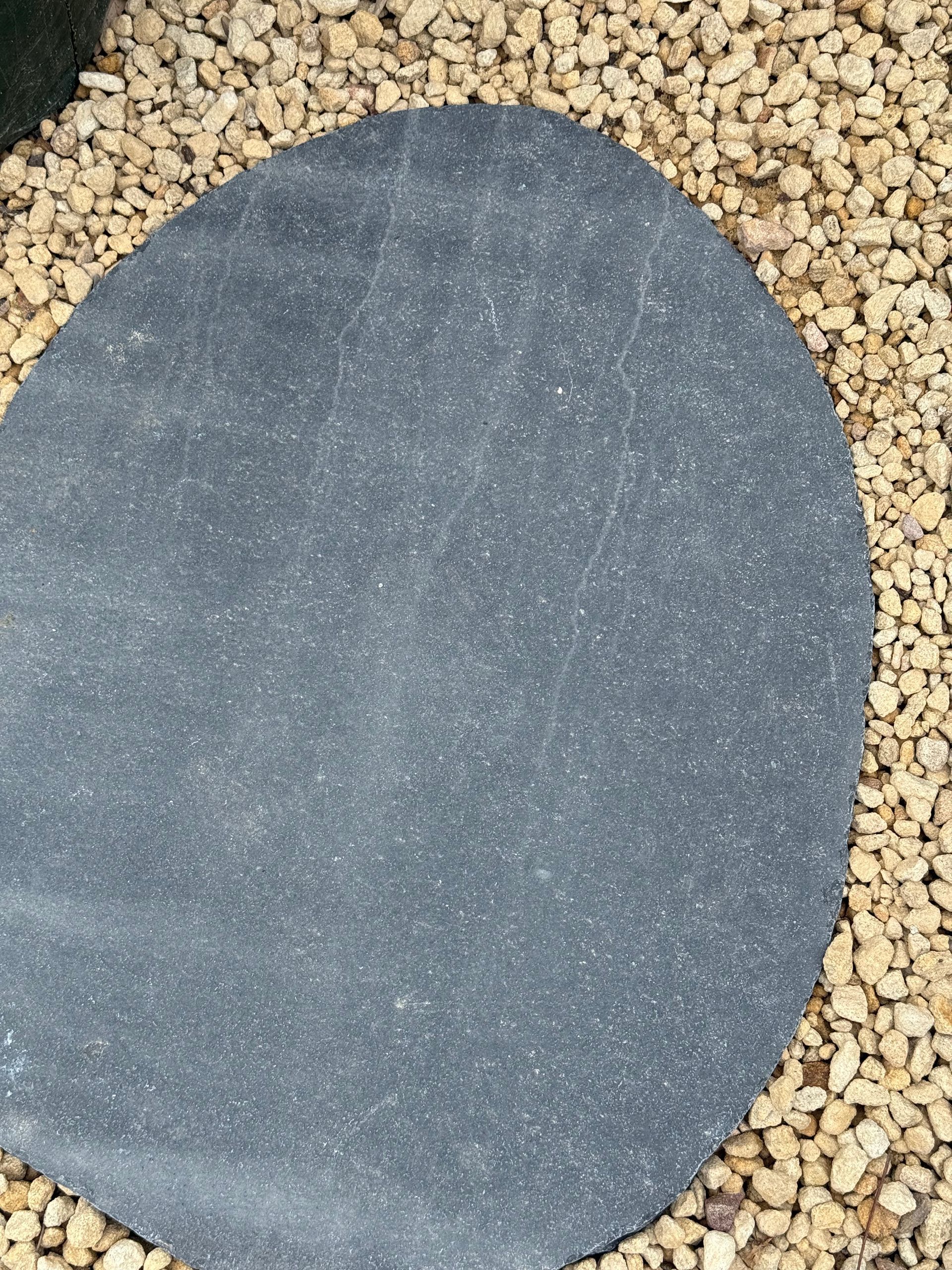 Dark gray, irregularly shaped stepping stone surrounded by small beige gravel — Schutz Landscape and Garden Supplies in Tomerong, NSW