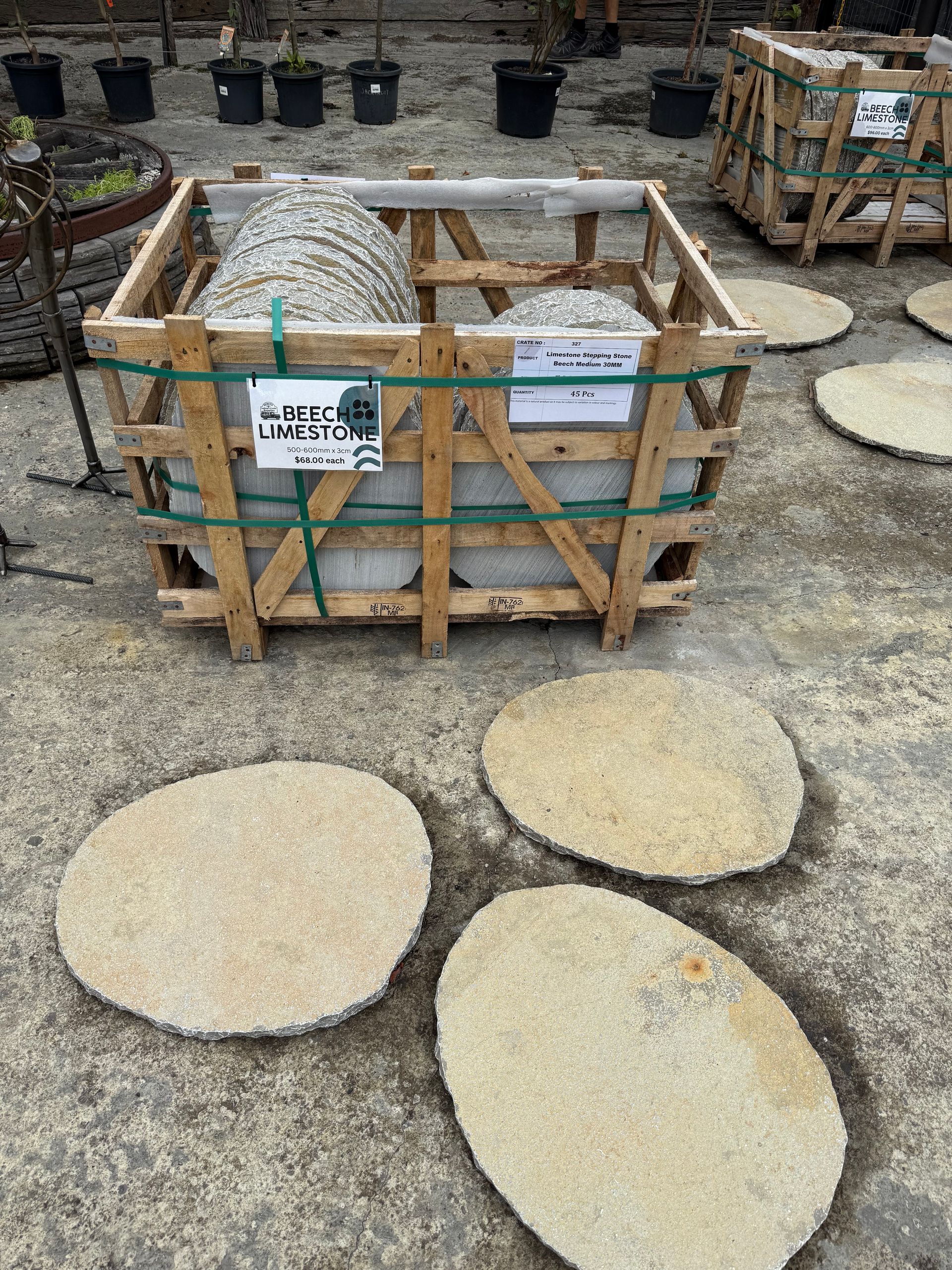 Wooden crate with large stones and several flat stepping stones on concrete ground — Schutz Landscape and Garden Supplies in Tomerong, NSW
