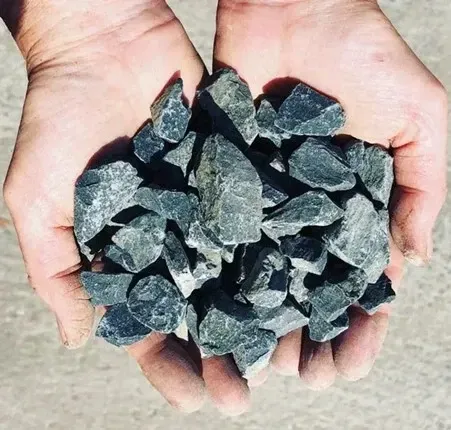 A Person Is Holding A Pile Of Rocks In Their Hands — Schutz Landscape and Garden Supplies in Tomerong, NSW