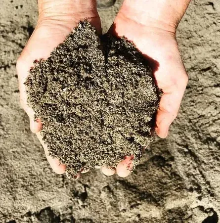 A Person Is Holding A Pile Of Sand In Their Hands — Schutz Landscape and Garden Supplies in Tomerong, NSW