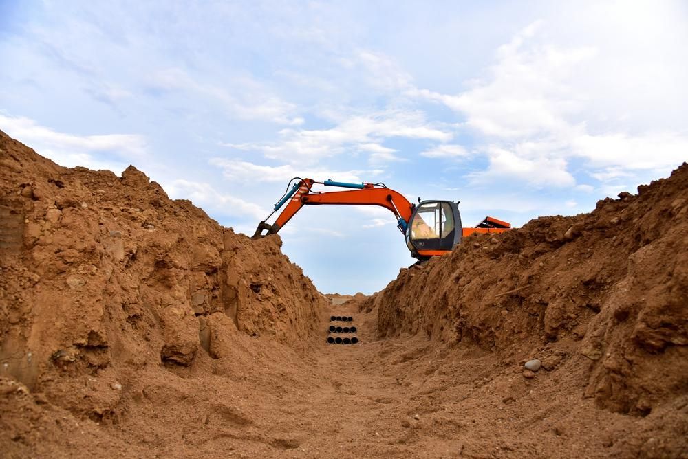 An Excavator Is Digging A Trench In The Dirt — Gympie Septic Pump Outs In Palmwoods, QLD