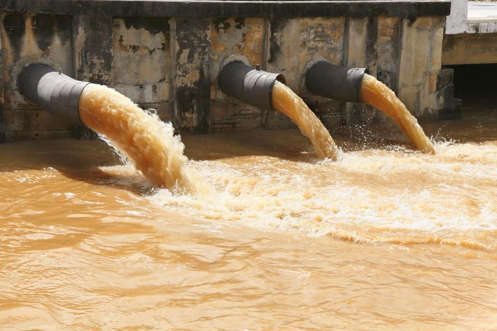 Three Pipes Are Pouring Brown Water Into A Body Of Water — Gympie Septic Pump Outs In Tin Can Bay, QLD
