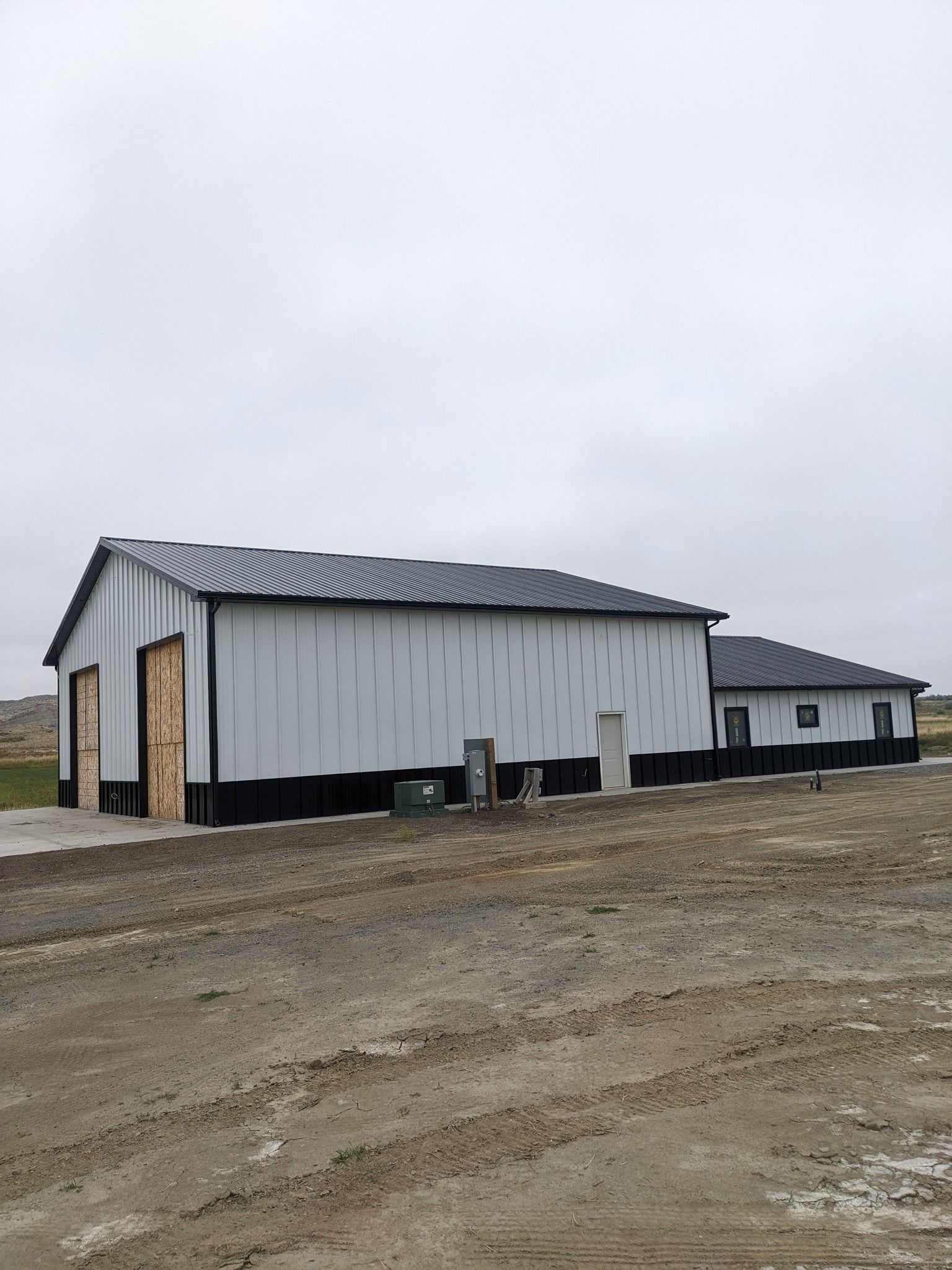 Gray industrial building with black accents under an overcast sky.