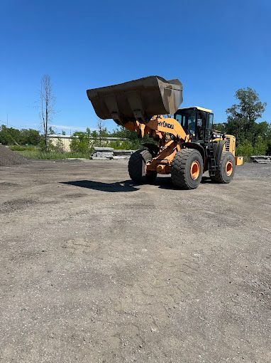 A bulldozer is parked in a gravel lot.