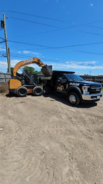 A truck is parked next to a bulldozer in a dirt lot.
