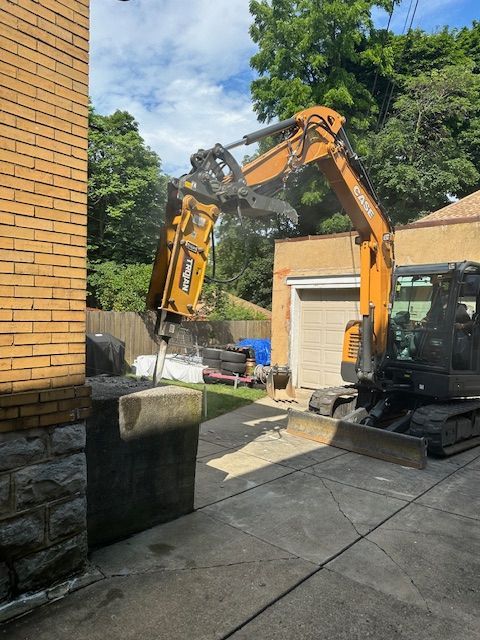 An excavator is being used to demolish a brick building