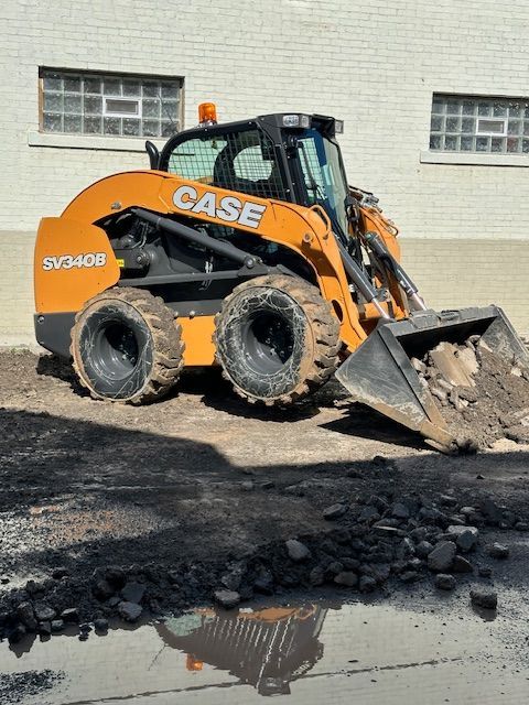 A case skid steer is working on a construction site